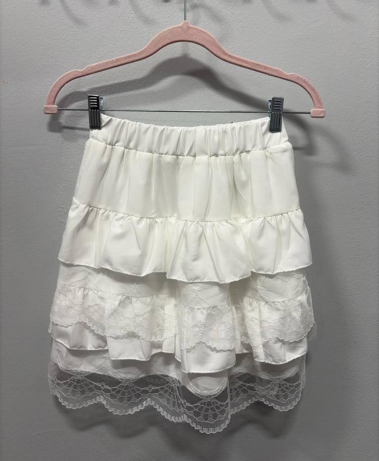 The Frosted Layers Ruffle Skort in white on a hanger.