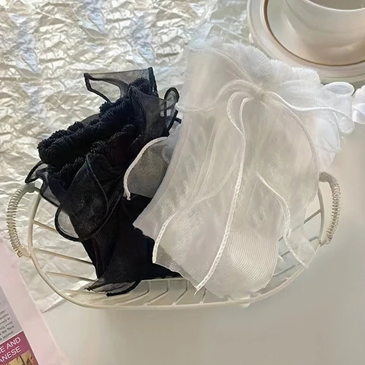 Styled folded view of the white and black versions of the Innocent Mischief Lace Socks with tulle bow.
