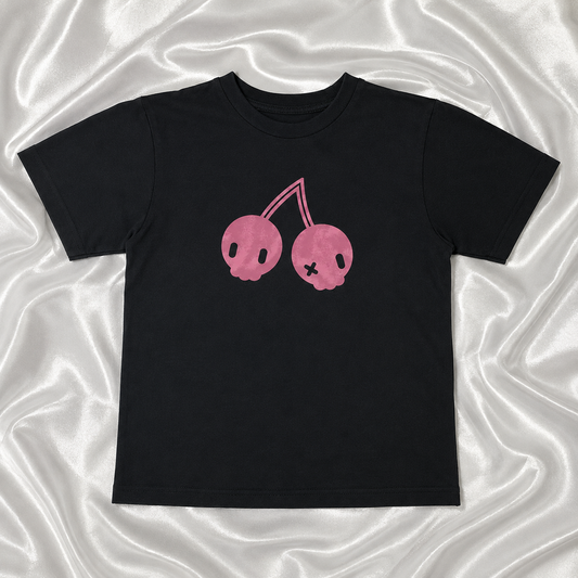 Flat lay of the Sweet Decay Cherry Tee on top of white satin fabric.