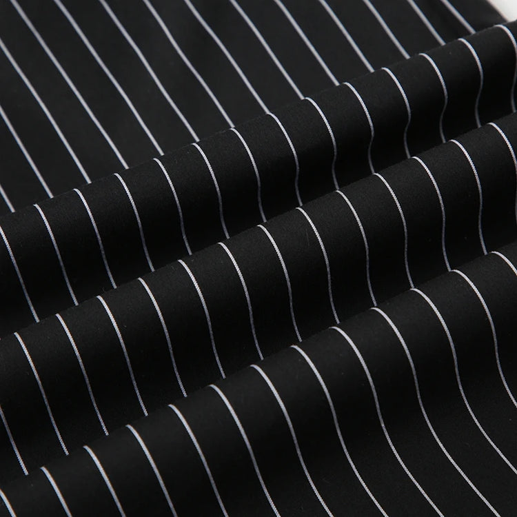 Close-up of Y2K Business Chic Trousers fabric showing crisp white pinstripes on smooth black broadcloth.