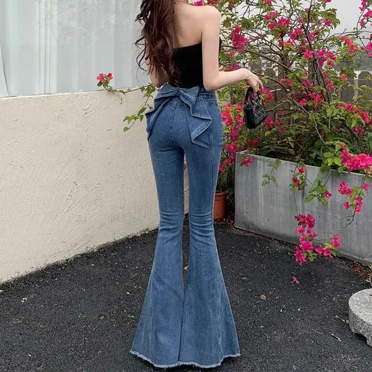 Model wearing the Dark Blue Backstage Bow Flare Jeans, front view.