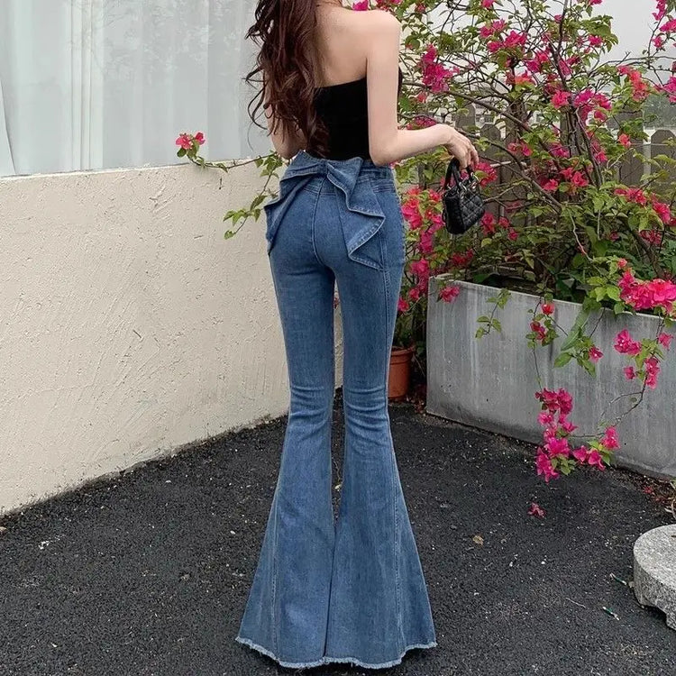 Model wearing the Dark Blue Backstage Bow Flare Jeans, front view.