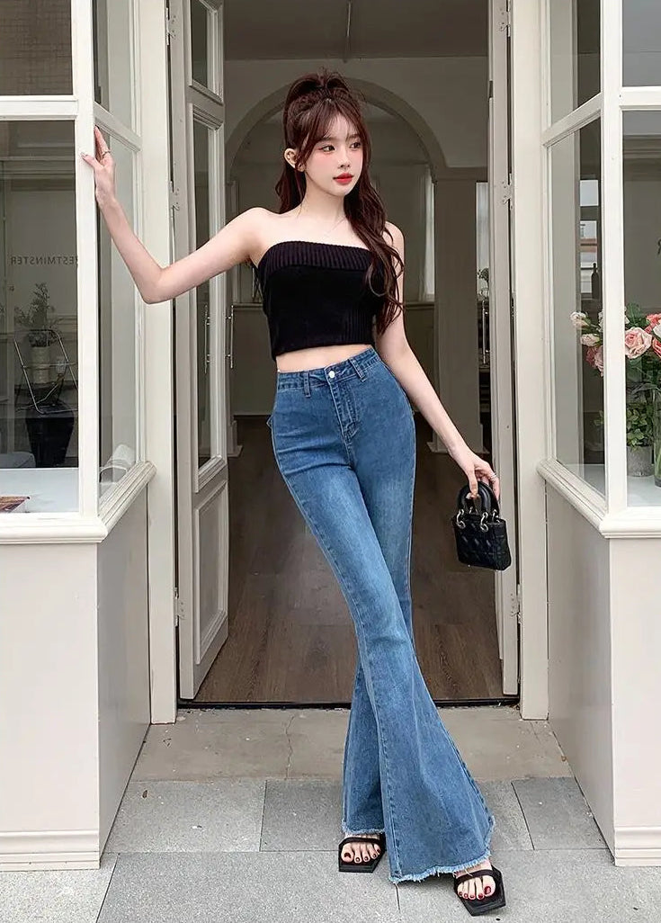 Model wearing the Dark Blue Backstage Bow Flare Jeans in a doorway, front view.