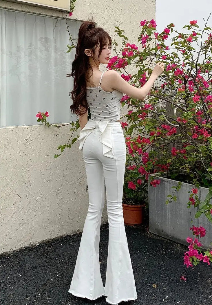 Angled back view of the white Backstage Bow Flare Jeans, highlighting the bow.