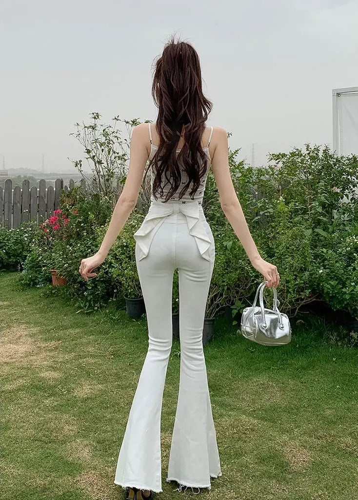 Model outdoors wearing the white Backstage Bow Flare Jeans.