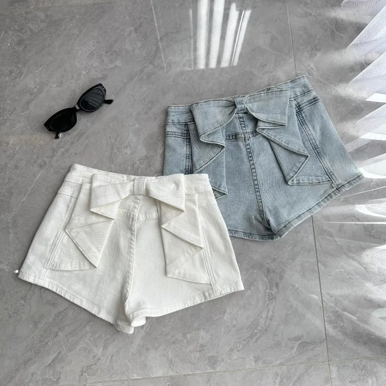 Flat lay of the Backstage Bow Shorts in white and light blue.