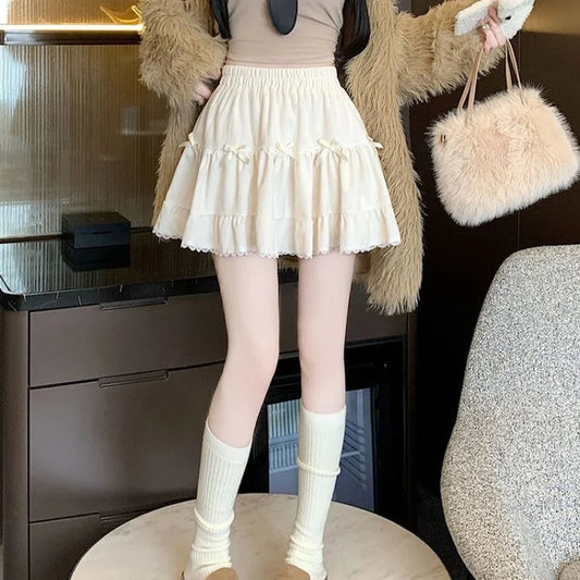 Front view of model wearing the Bow Peep Mini Skort in Apricot, showcasing pleats.