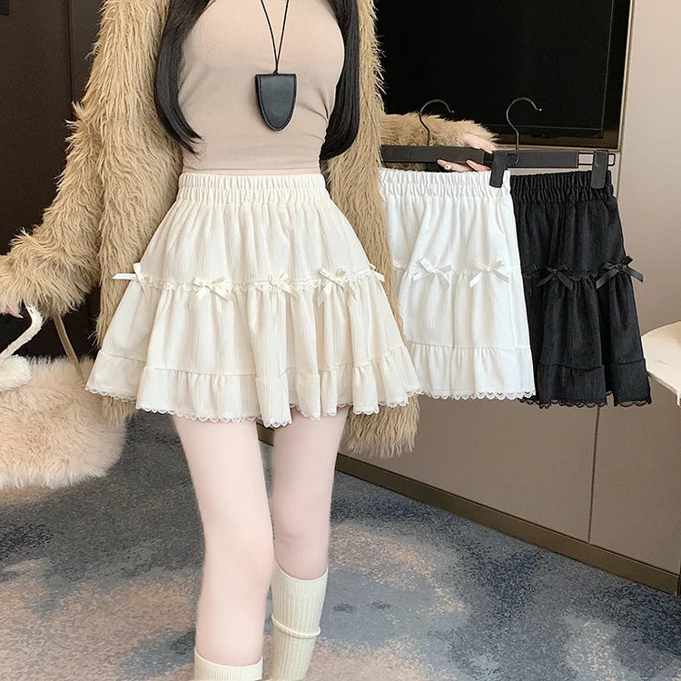 Model wearing the apricot Bow Peep Mini Skort while holding the black and white versions on hangers.