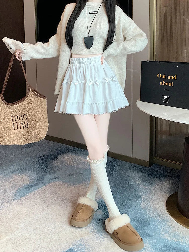 Front view of model posing in the Bow Peep Mini Skort in White with pleats and bow details.