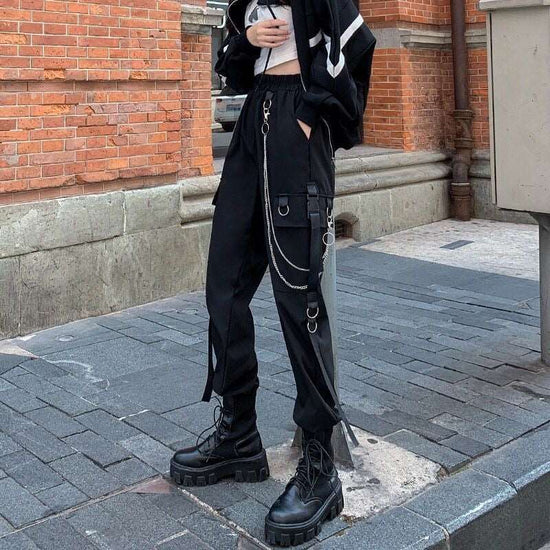 Side angle of model wearing black Chain Reaction Cargo Joggers showing flap pocket and hanging chain