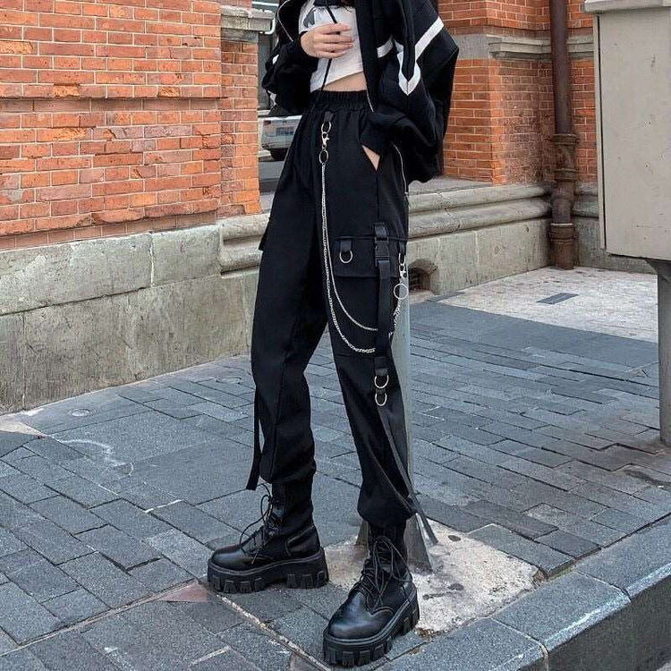 Side angle of model wearing black Chain Reaction Cargo Joggers showing flap pocket and hanging chain