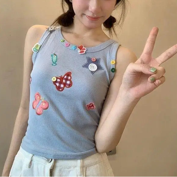 Model wearing the pale periwinkle blue Charm Collector Tank and making a peace sign indoors.