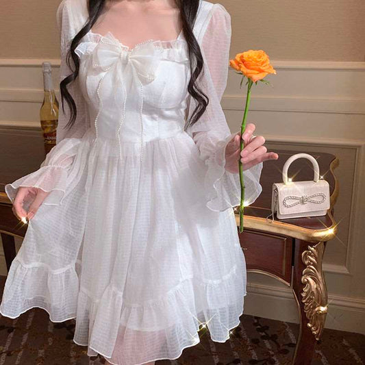 Model wearing the Cloudlight Fairy Dress holding the dress and an orange rose, front view
