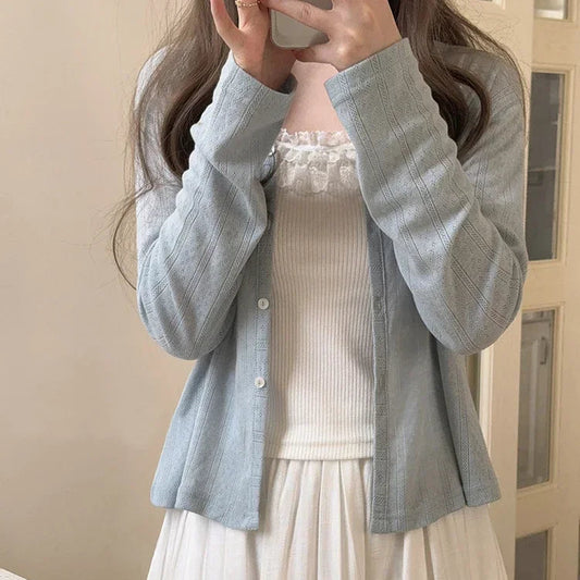 Model wearing the Cloudy Daydream Cardigan in soft blue with button-up front and long sleeves.