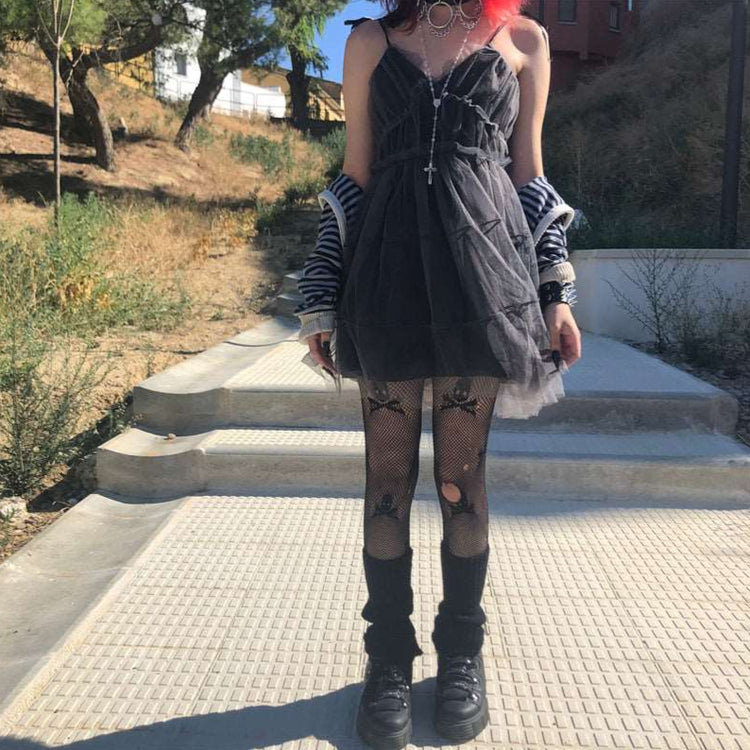 Model wearing Dark Fairy Tulle Dress outdoors full-body view, styled with black shoes, a striped jacket, fishnet skull tights, and leg warmers