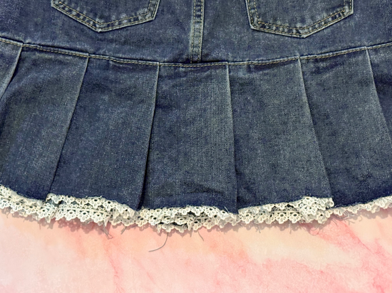 Close-up of back pleats and lace trim detail on the Denim Daydream Pleated Lace Skort