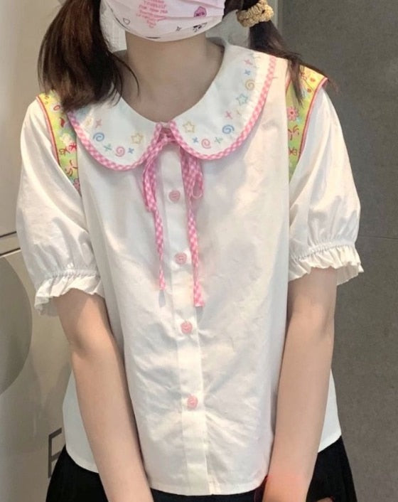 Doodle Darling Collar Blouse worn in a standing front view with pink buttons and ribbon tie visible