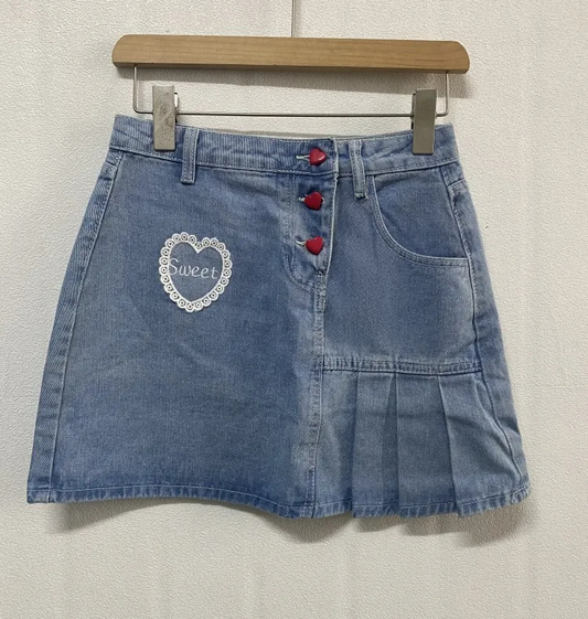 The Dual Darling Denim Skirt hanging on the hanger without added bows