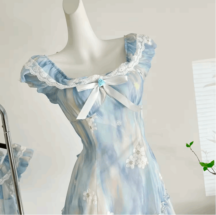 Detailed close-up of the neckline on the mini Ethereal Flower Princess Dress, showcasing the lace trim, bow-detail, and flower embellishments.