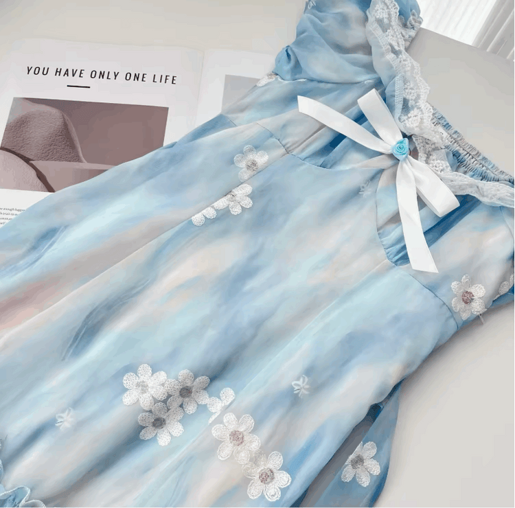 A close-up on the flat lay of the mini Ethereal Flower Princess Dress, showcasing its bow detailing and flower embellishments.