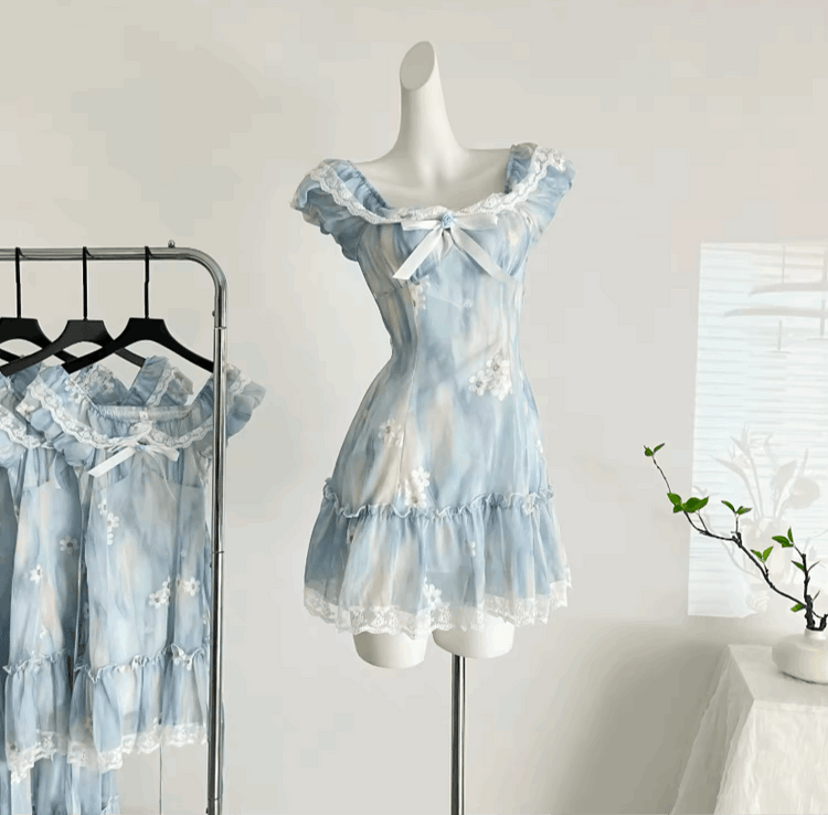 A close-up of the mini Ethereal Flower Princess Dress on a mannequin next to a rack hanging the mini and midi versions of the dress.