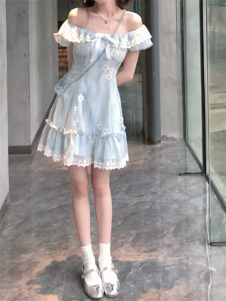 A model wearing the mini Ethereal Flower Princess Dress off the shoulder, showcasing its short puffed sleeves, a square neckline, lace detailing, and bow embellishment at the front.