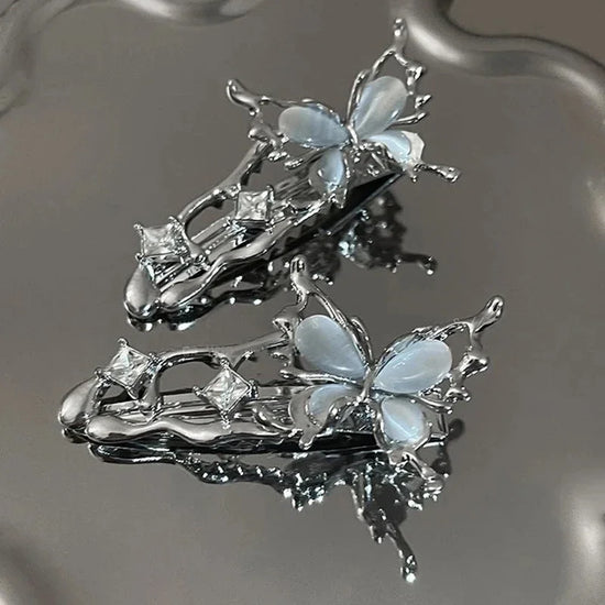 Flatlay of two Liquid Metal Butterfly Hair Clips arranged aesthetically.
