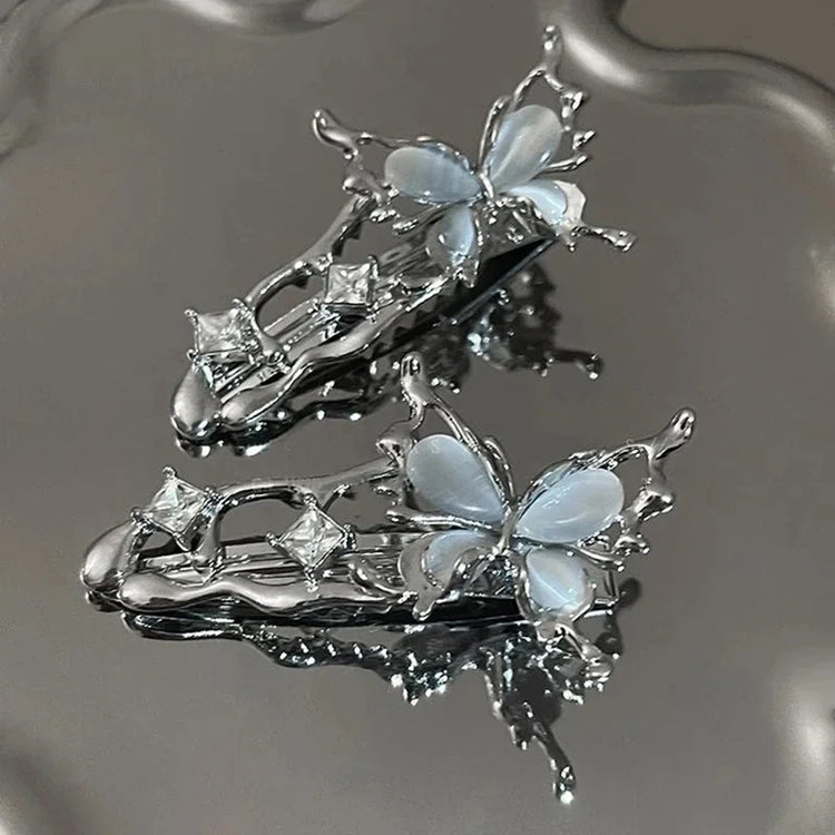 Flatlay of two Liquid Metal Butterfly Hair Clips arranged aesthetically.