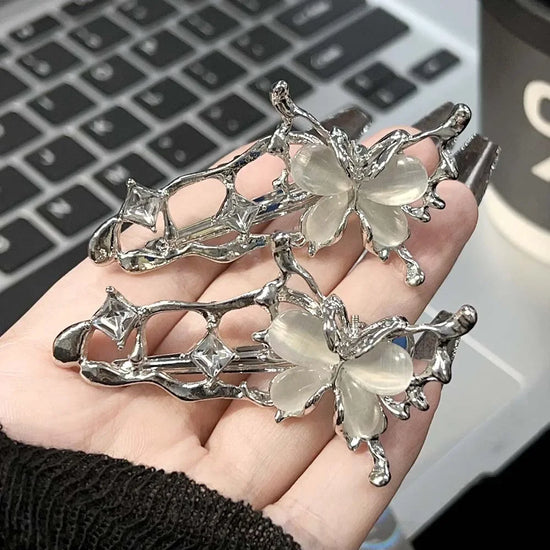 Hand holding Liquid Metal Butterfly Hair Clips showing its detailed silver design.
