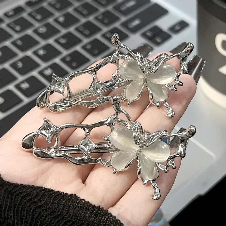 Hand holding Liquid Metal Butterfly Hair Clips showing its detailed silver design.