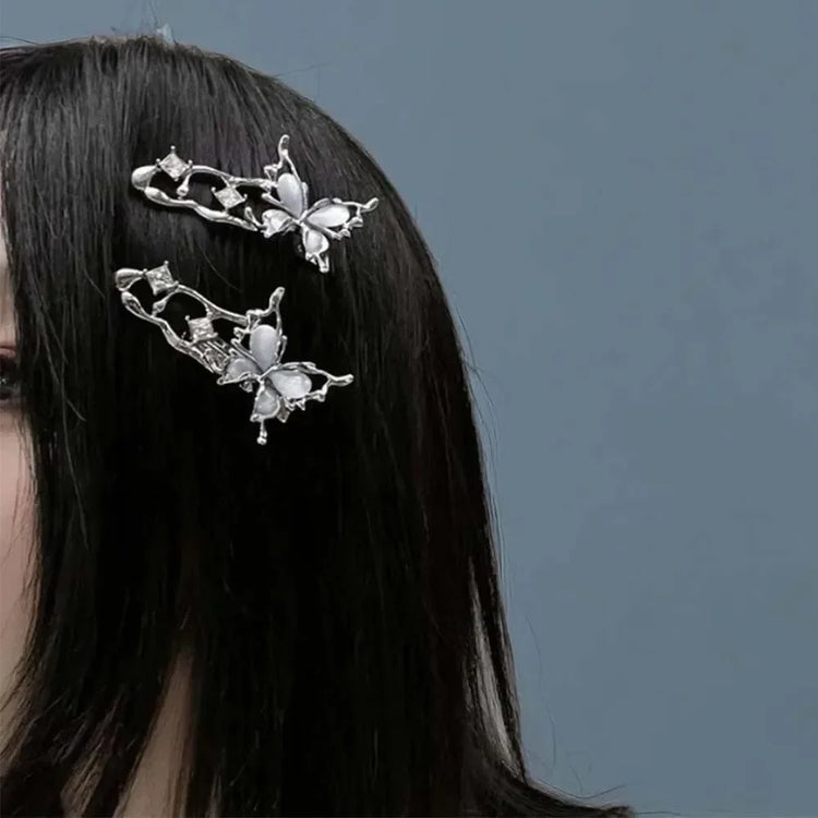 Profile view of model wearing two Liquid Metal Butterfly Hair Clips in front of a gray background.