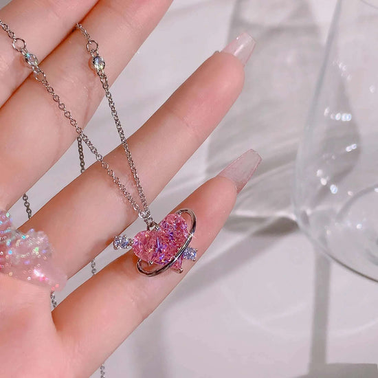 Love Orbit Necklace held in hand, highlighting gemstone and rhinestone orbit