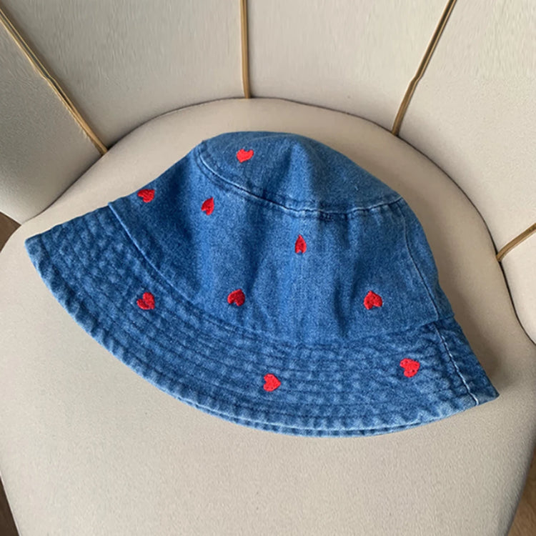 A dark blue version of the Love Stitch Denim Bucket Hat featuring evenly spaced red heart embroidery on soft denim fabric.