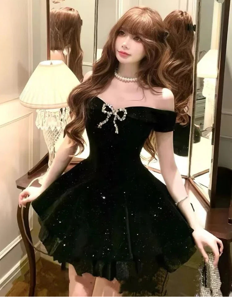 Model leaning on a table in the Midnight Gala Bow Dress.