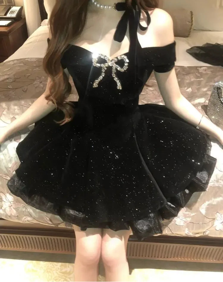 Front view of a model sitting in the Midnight Gala Bow Dress, showing the sparkly velvet and jeweled bow.