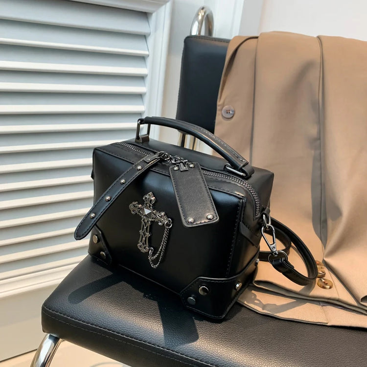 Moonlit Mourning Crossbody with the cross design displayed on a chair.