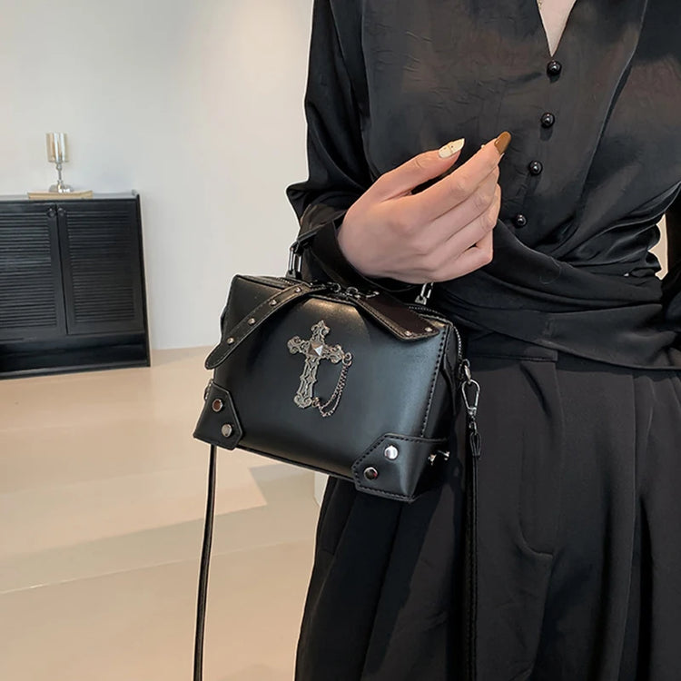 Moonlit Mourning Crossbody carried by the top handle with the cross design.