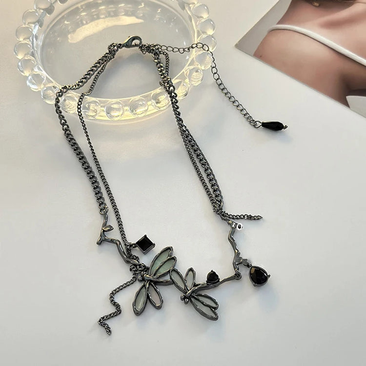 Flat lay display of the Moonvine Dragonfly Necklace showing the dragonfly-inspired centerpiece and asymmetrical chain design.
