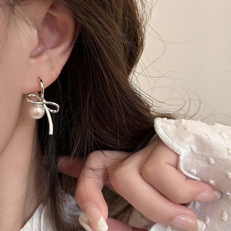 Model wearing Silver Pearl Whim Bow Earrings close-up
