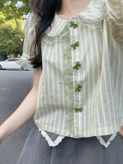 Street style view of Pistachio Ribbon Striped Blouse with lace trim and bow buttons