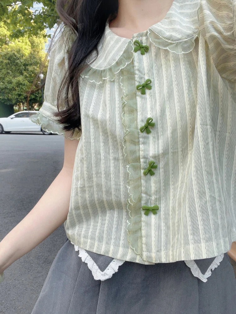 Street style view of Pistachio Ribbon Striped Blouse with lace trim and bow buttons