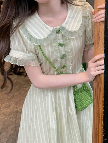 Close-up of the Pistachio Ribbon Striped Dress showing lace collar and green bow button details.