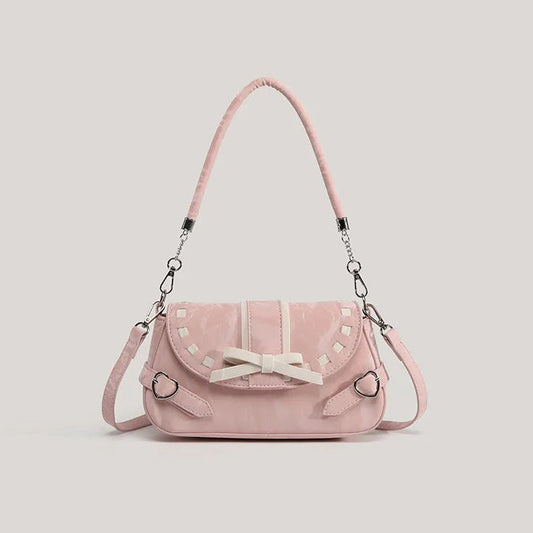 Pink Ribbon Romance Shoulder Bag with a soft velvety finish, statement ribbon bow, interwoven ribbon detailing, and heart-shaped buckle accents.