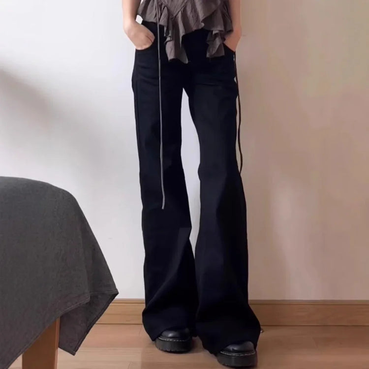 Model wearing the Rogue Rise Rigid Flare Jeans with a strapped brown blouse.