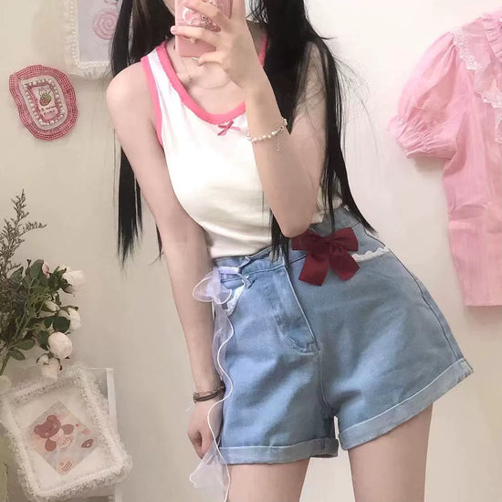 Front view of Scarlet Sweetheart High-Rise Shorts on standing model, featuring light blue denim, high-waisted fit, red bow, and lace trim pockets