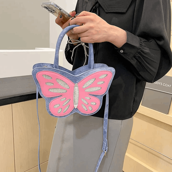 Blue and pink Sparkling Butterfly Handbag being held in front of a model's body