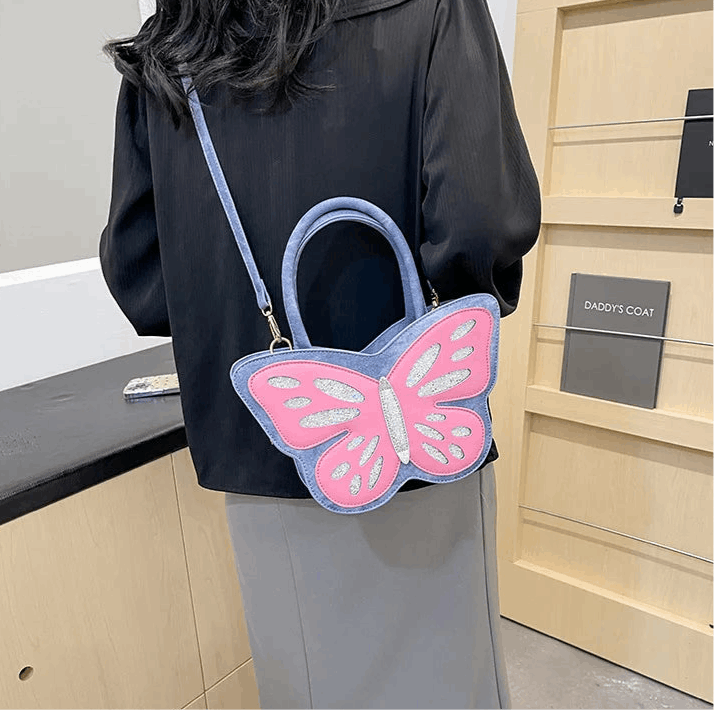 Blue and pink Sparkling Butterfly Handbag worn crossbody the back of a model
