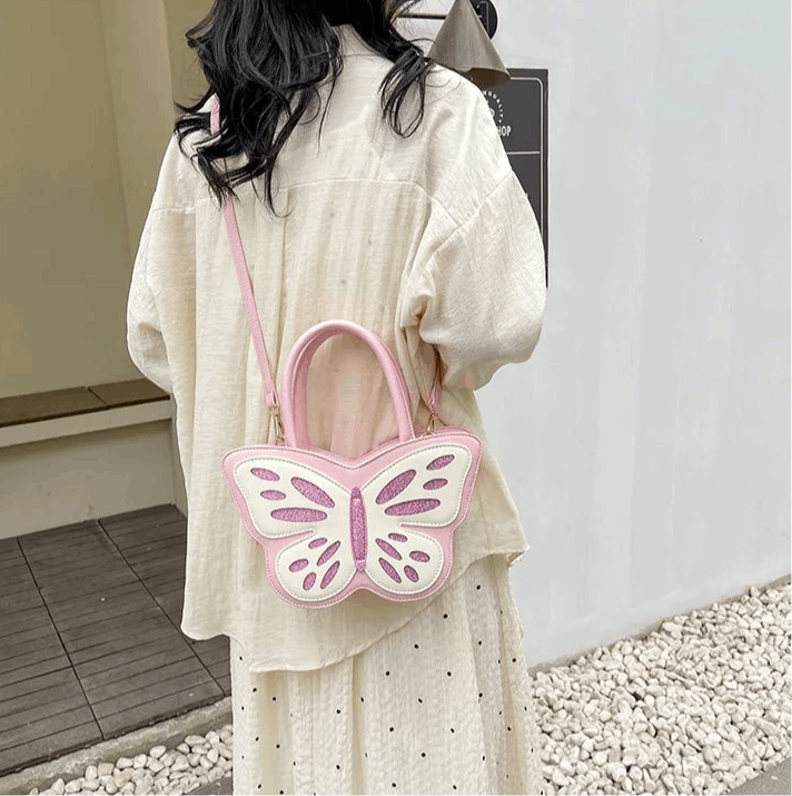 Model wearing Sparkling Butterfly Handbag in pink and white across the back of her body