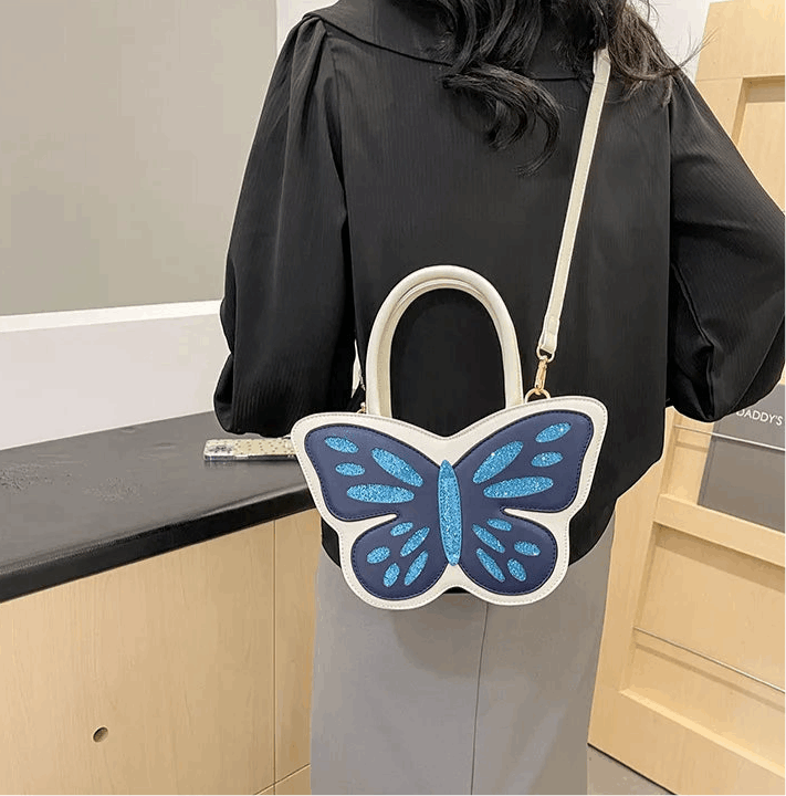 Model wearing Sparkling Butterfly Handbag in white and blue with crossbody strap behind their back