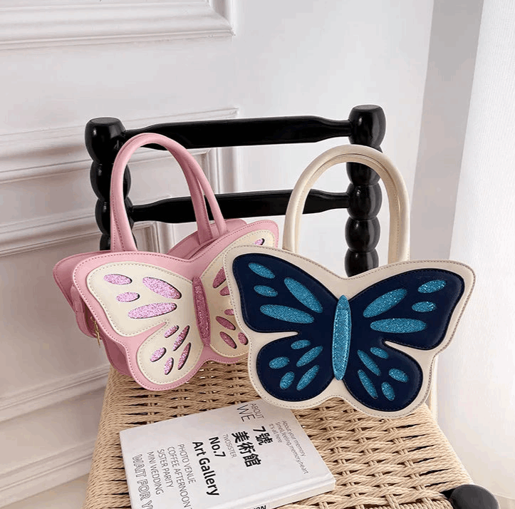 Sparkling Butterfly Handbag in pink and white and white and blue propped up against a chair